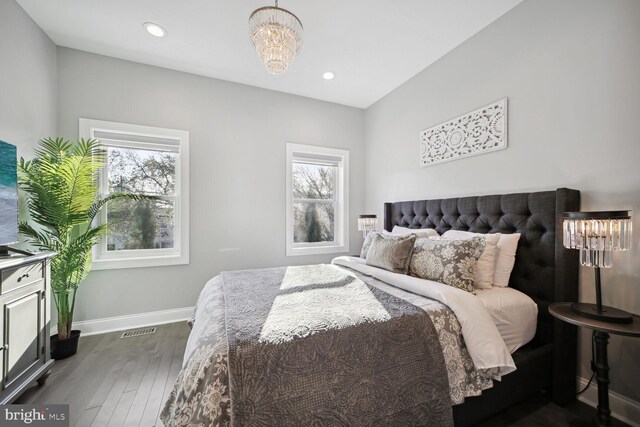 bedroom with dark wood-type flooring, multiple windows, baseboards, and visible vents