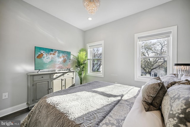 bedroom featuring a notable chandelier, baseboards, and dark wood-style flooring