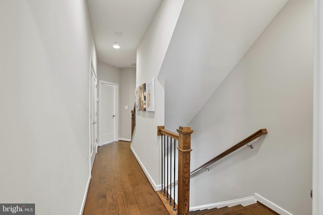 hall featuring recessed lighting, baseboards, an upstairs landing, and wood finished floors