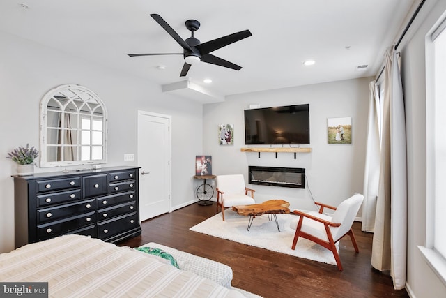 bedroom featuring visible vents, a ceiling fan, a glass covered fireplace, recessed lighting, and dark wood-style flooring