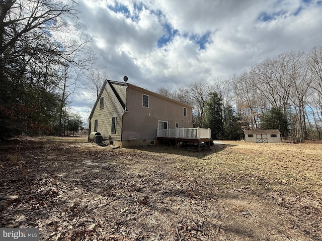 exterior space with an outbuilding, a shed, a deck, and central air condition unit