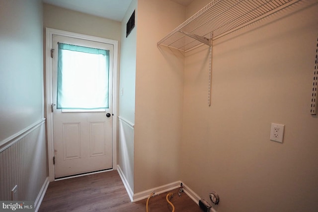 laundry room featuring a wainscoted wall, wood finished floors, and visible vents