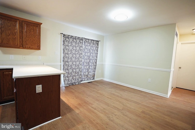 kitchen featuring light wood-style floors, baseboards, and light countertops