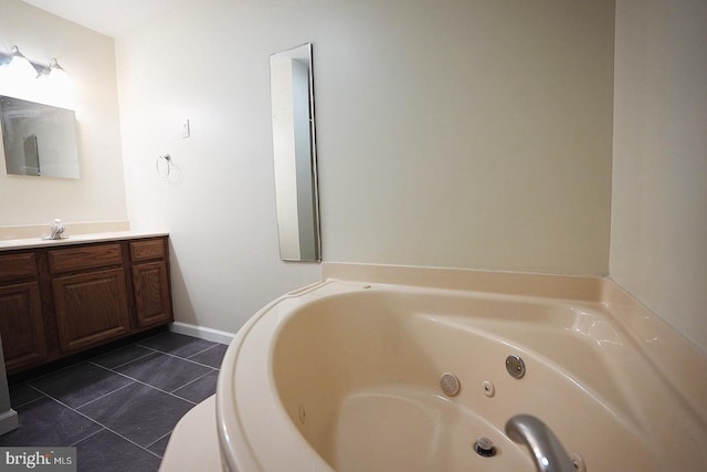 bathroom with a jetted tub, vanity, and tile patterned floors