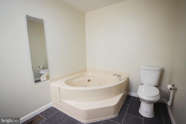 full bathroom featuring tile patterned flooring, baseboards, a jetted tub, and toilet