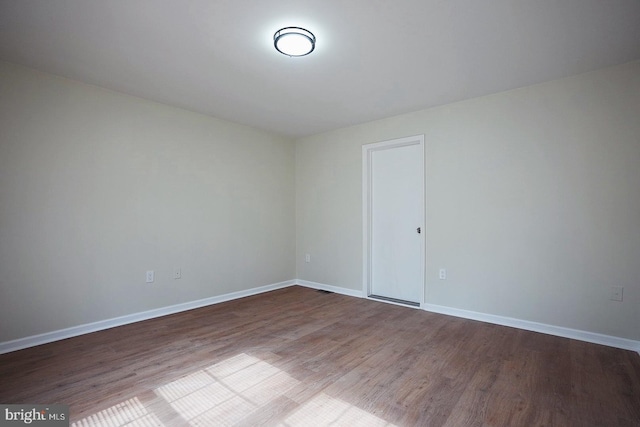 unfurnished room featuring wood finished floors and baseboards