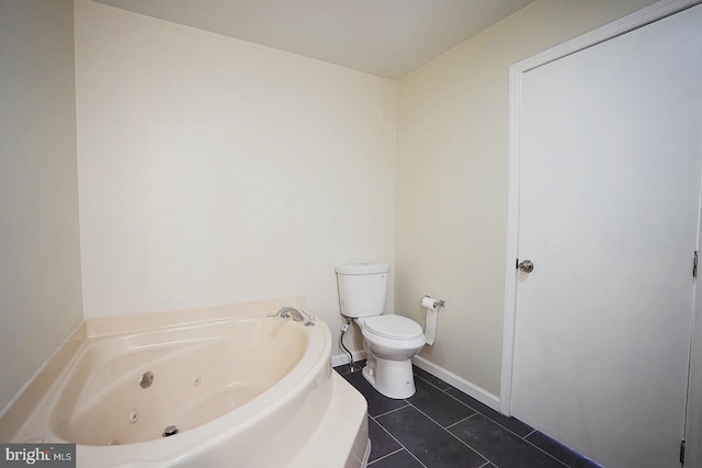 bathroom featuring a jetted tub, baseboards, toilet, and tile patterned floors