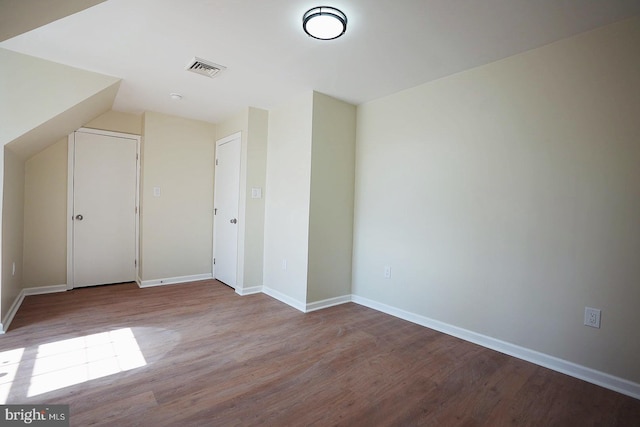 bonus room featuring wood finished floors, visible vents, and baseboards