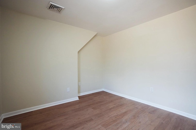 empty room featuring visible vents, baseboards, and wood finished floors