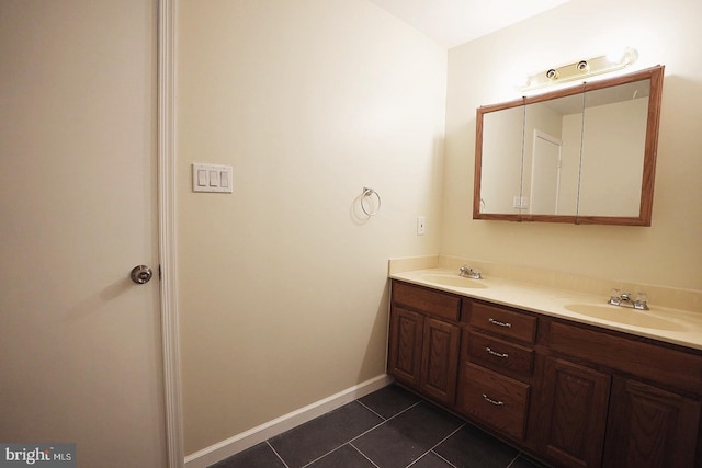 bathroom with double vanity, tile patterned flooring, baseboards, and a sink