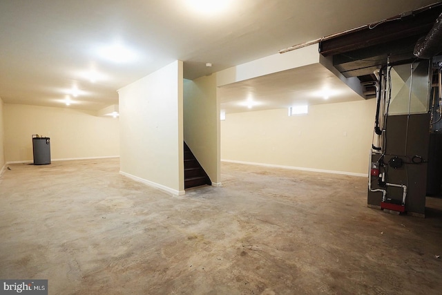 finished basement with heating unit, stairs, and baseboards