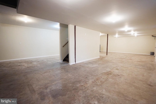 finished basement featuring baseboards and stairs