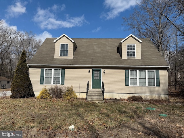 cape cod home with entry steps and a front lawn