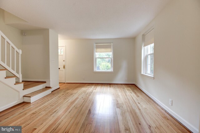 4911 29th Rd S, Arlington, VA 22206 - unfurnished living room featuring healthy amount of natural light, stairs, hardwood / wood-style flooring, and baseboards