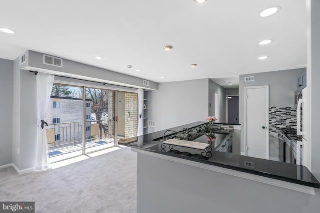 kitchen with visible vents, a sink, carpet floors, decorative backsplash, and stainless steel gas range