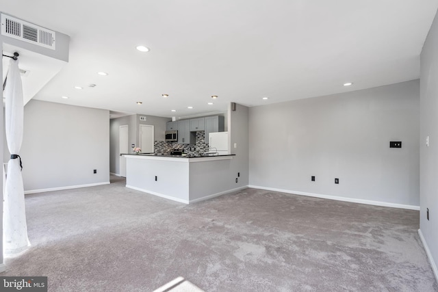 unfurnished living room featuring light colored carpet, recessed lighting, baseboards, and visible vents