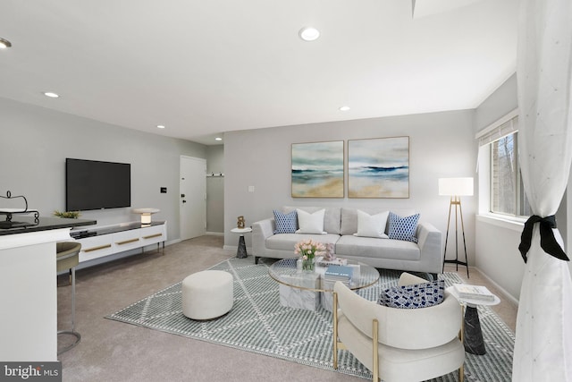 carpeted living area with recessed lighting and baseboards