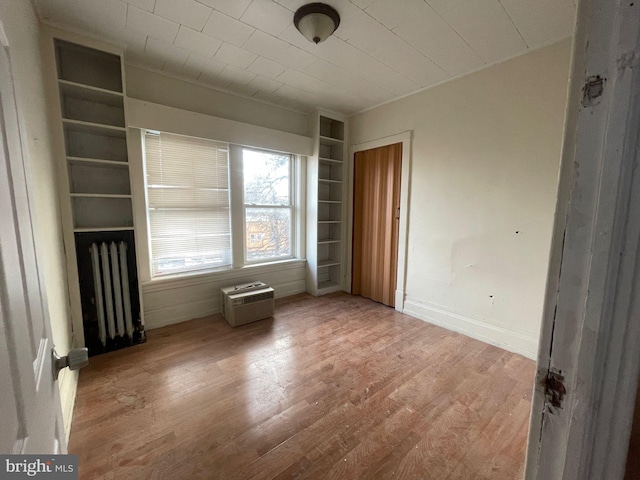 interior space with radiator, light wood finished floors, and baseboards