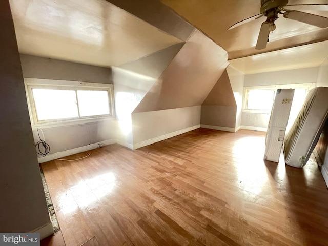 bonus room with lofted ceiling, ceiling fan, wood finished floors, and baseboards