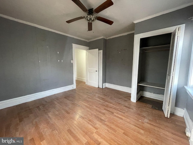 unfurnished bedroom featuring baseboards, light wood-style flooring, ceiling fan, ornamental molding, and a closet