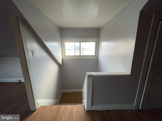 stairway featuring baseboards and wood finished floors