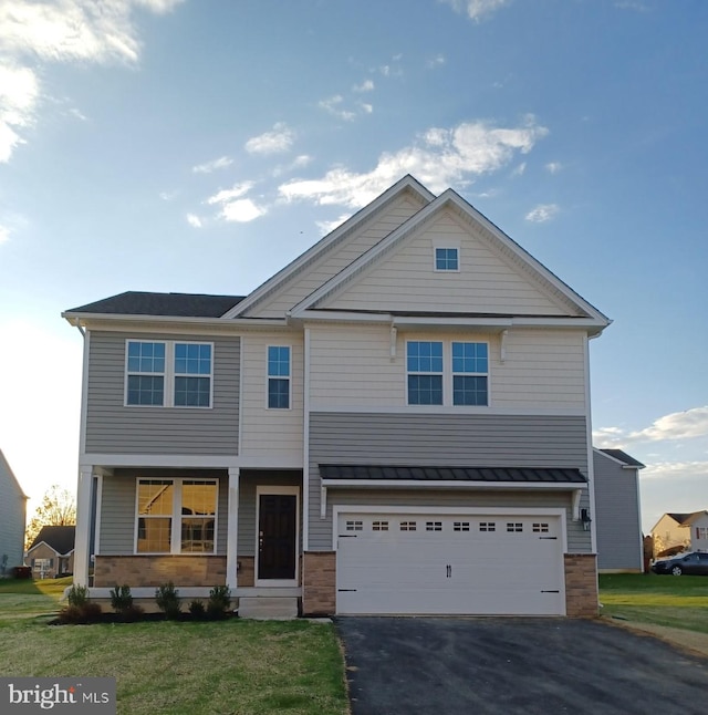 view of front of property with aphalt driveway, covered porch, a standing seam roof, a garage, and a front lawn