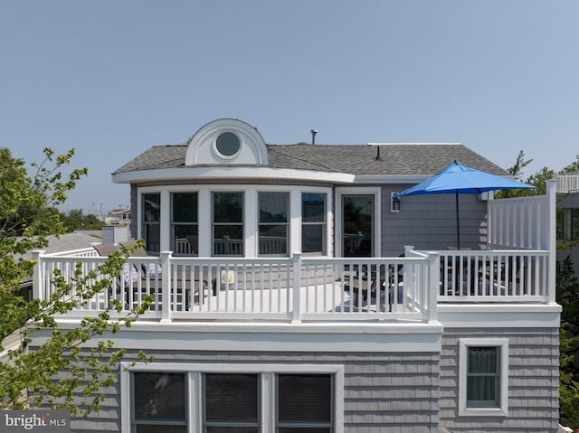 back of house with roof with shingles