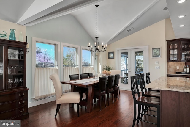 dining space featuring a healthy amount of sunlight, dark wood-style floors, and vaulted ceiling