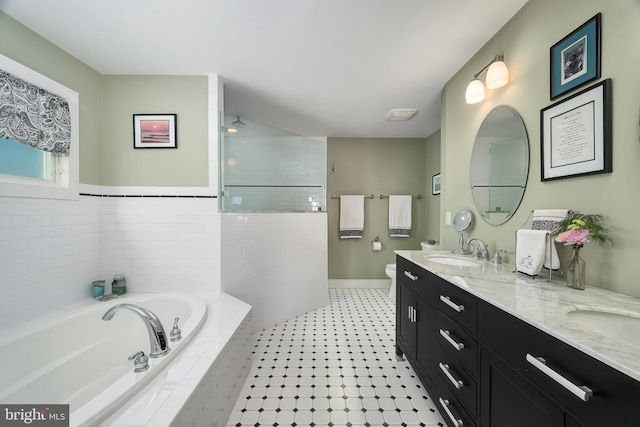 full bathroom with a sink, a garden tub, double vanity, and toilet