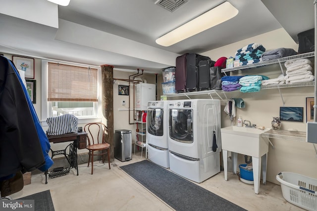 washroom featuring washing machine and clothes dryer, visible vents, water heater, and laundry area