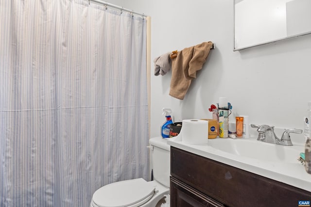 bathroom featuring toilet, a shower with shower curtain, and vanity