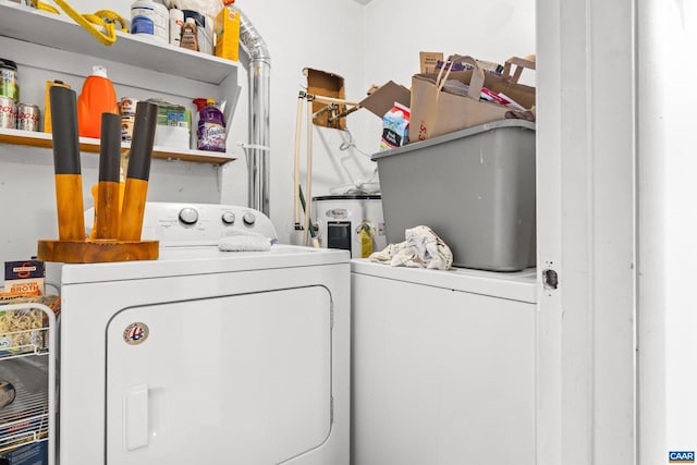 laundry room featuring laundry area, water heater, and separate washer and dryer