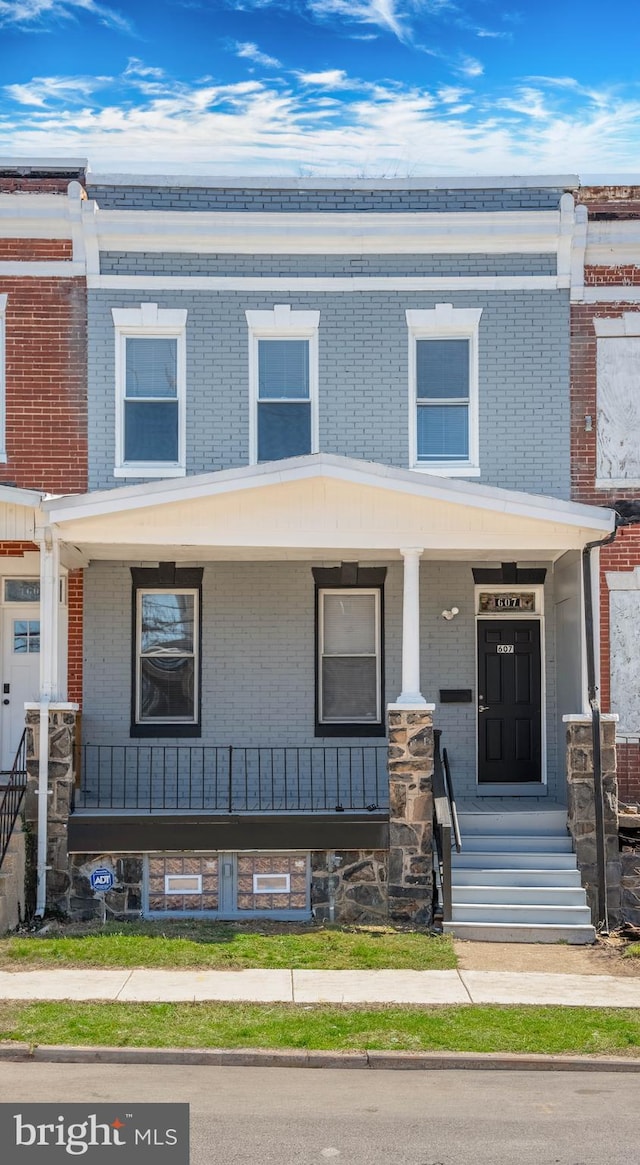 multi unit property with brick siding and covered porch