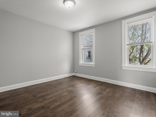 607 N Longwood St, Baltimore, MD 21216 - empty room with baseboards and dark wood-type flooring