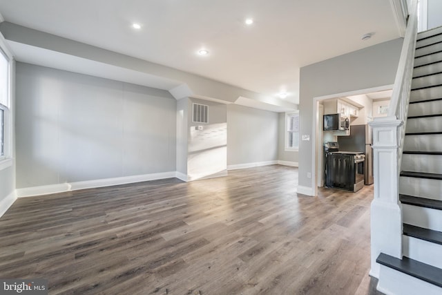 unfurnished living room featuring visible vents, baseboards, stairs, recessed lighting, and wood finished floors