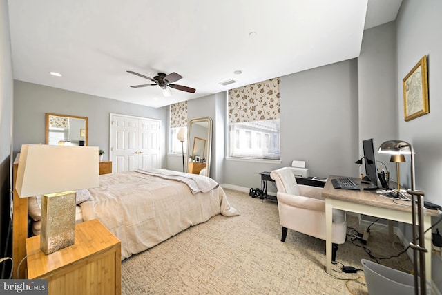 carpeted bedroom with a closet, visible vents, a ceiling fan, and baseboards