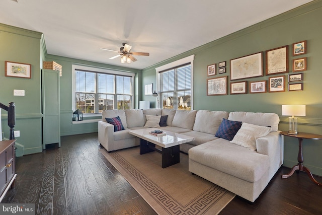 living room with ceiling fan, baseboards, dark wood-type flooring, and ornamental molding