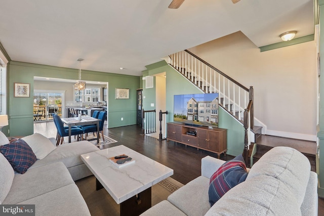 living area featuring visible vents, stairs, baseboards, and wood finished floors