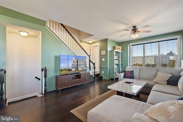 living room with stairway, ceiling fan, baseboards, and wood finished floors