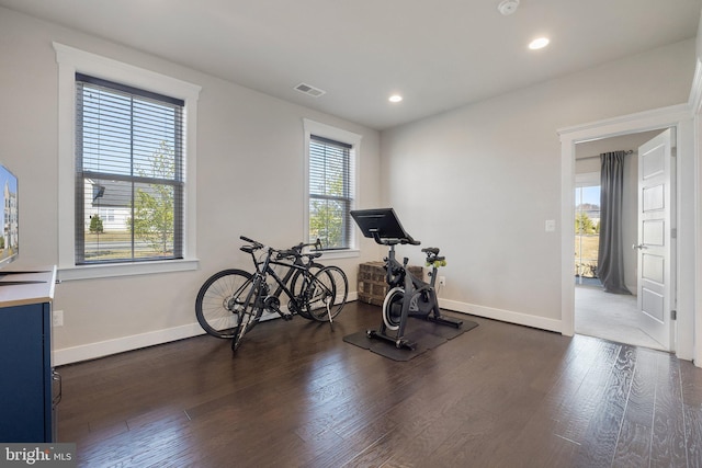 exercise area featuring dark wood finished floors, visible vents, recessed lighting, and baseboards