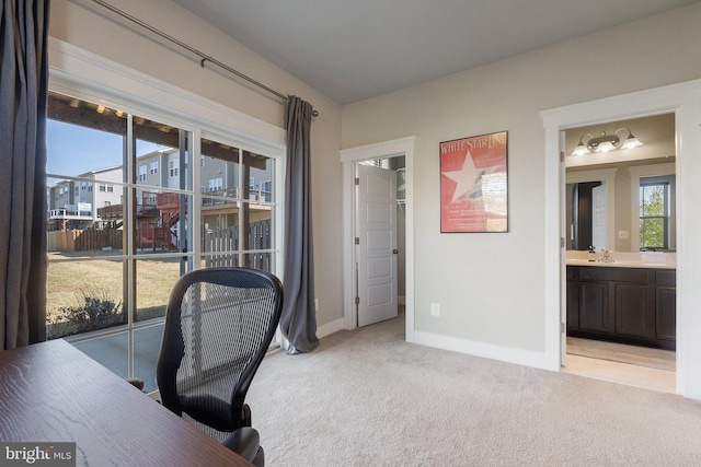 office with baseboards, light carpet, and a healthy amount of sunlight