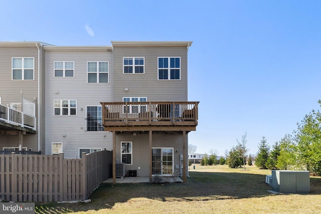 rear view of property featuring cooling unit, a yard, and fence