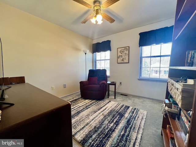 living area featuring baseboards, carpet, and ceiling fan