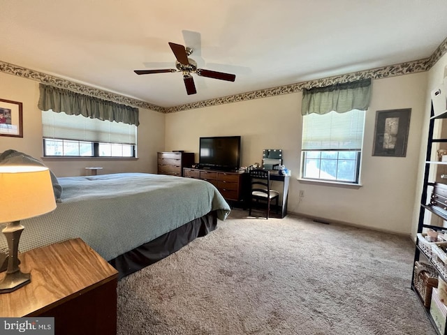 bedroom with multiple windows, a ceiling fan, and carpet floors