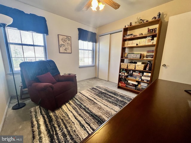 living area featuring carpet and ceiling fan