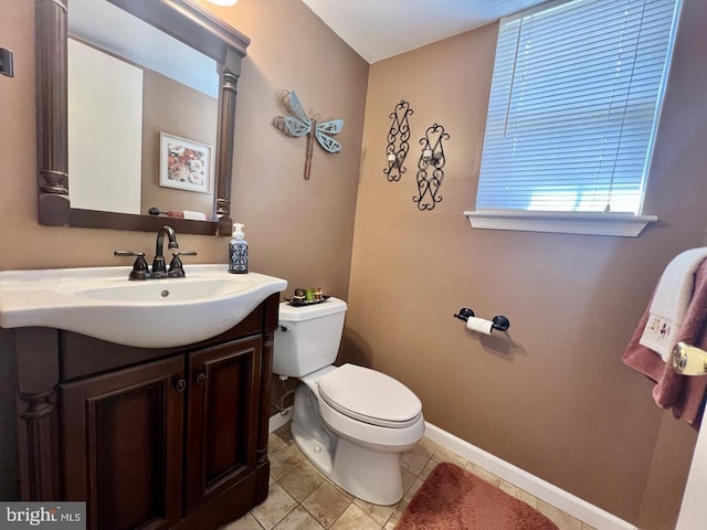 bathroom with tile patterned floors, baseboards, toilet, and vanity