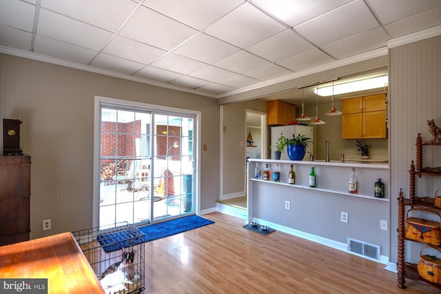 interior space with visible vents, a paneled ceiling, light wood-style flooring, and freestanding refrigerator