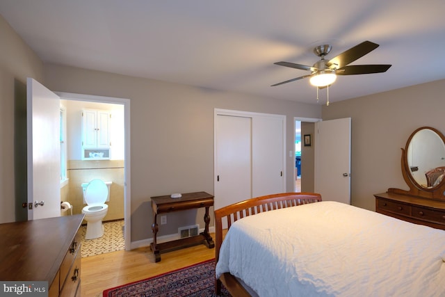 bedroom featuring visible vents, ceiling fan, light wood-style floors, a closet, and ensuite bathroom