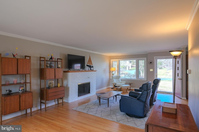 living room featuring a brick fireplace, light wood-style flooring, baseboards, and ornamental molding