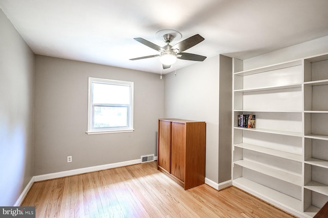 unfurnished bedroom with visible vents, ceiling fan, baseboards, and wood finished floors